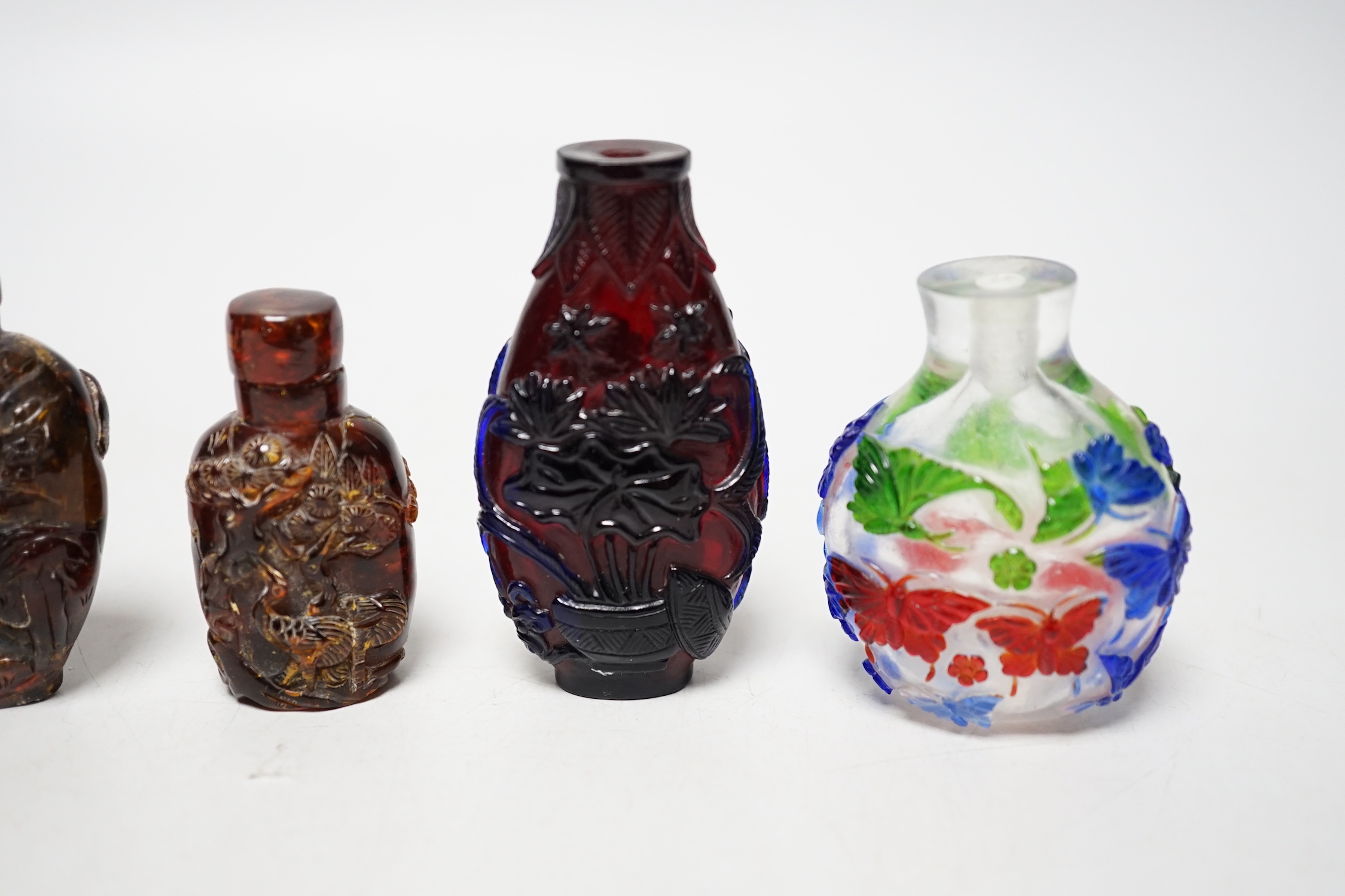 Five Chinese glass or amber snuff bottles, 7.4 cm high